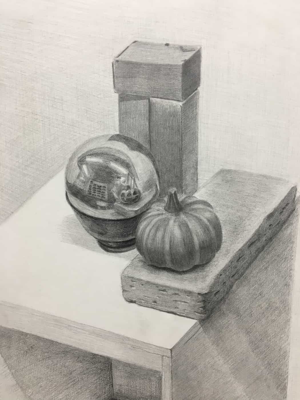 Pencil drawing of a pumpkin, mirror ball, and brick on a table.