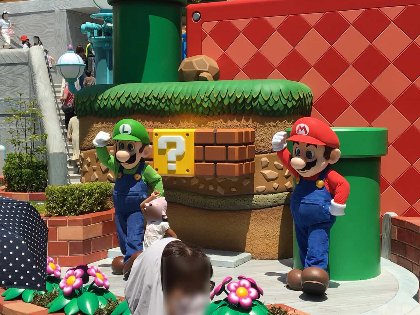 Mario & Luigi joyfully posing for pictures with delighted visitors at Super Nintendo World.