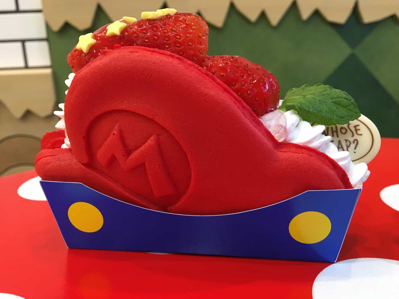 A delicious treat shaped like Mario's hat, topped with whipped cream and strawberries.