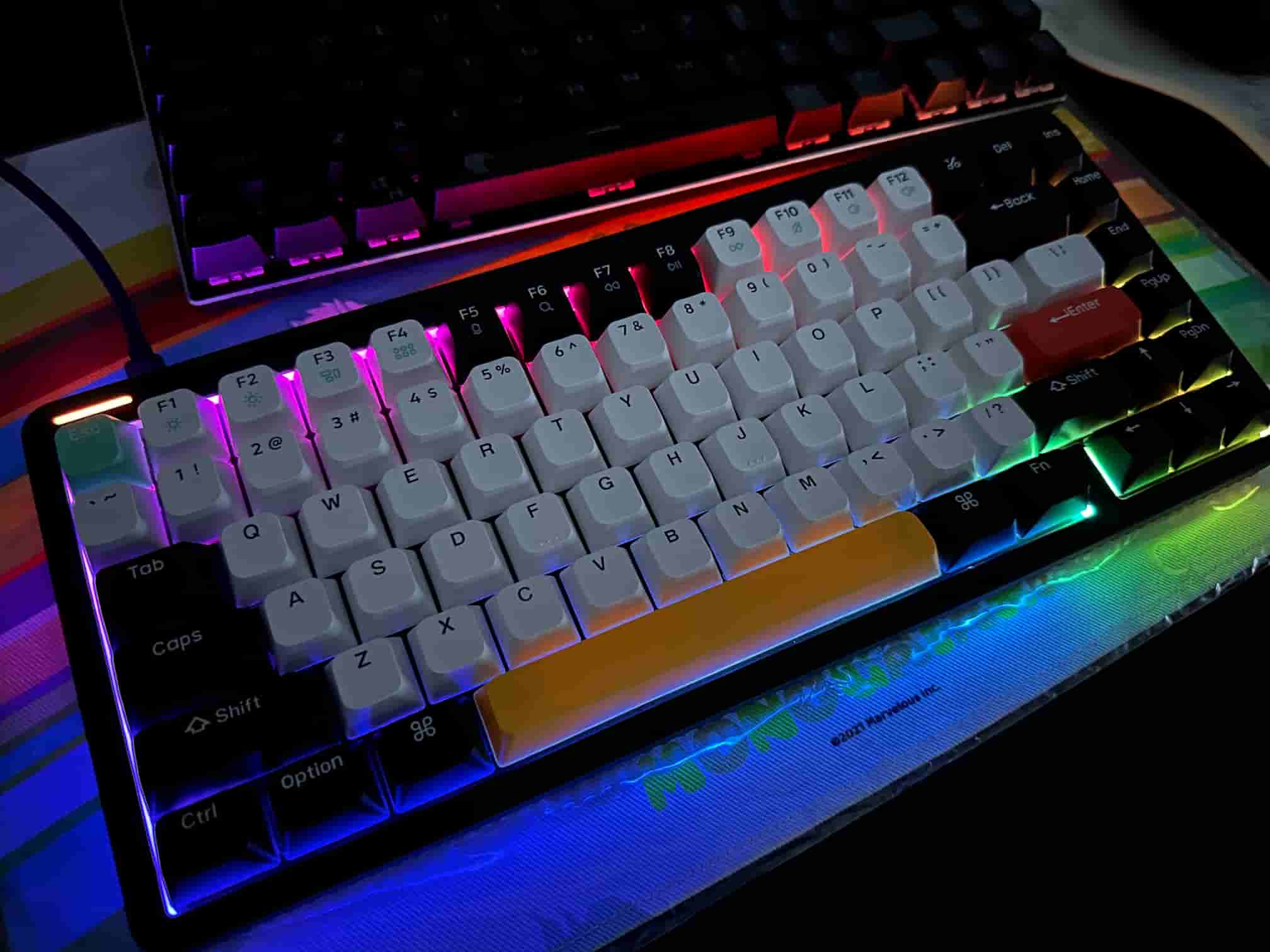 Illuminated NuPhy Halo75 mechanical keyboard with backlit keys in various colors, showcasing a vibrant RGB light display