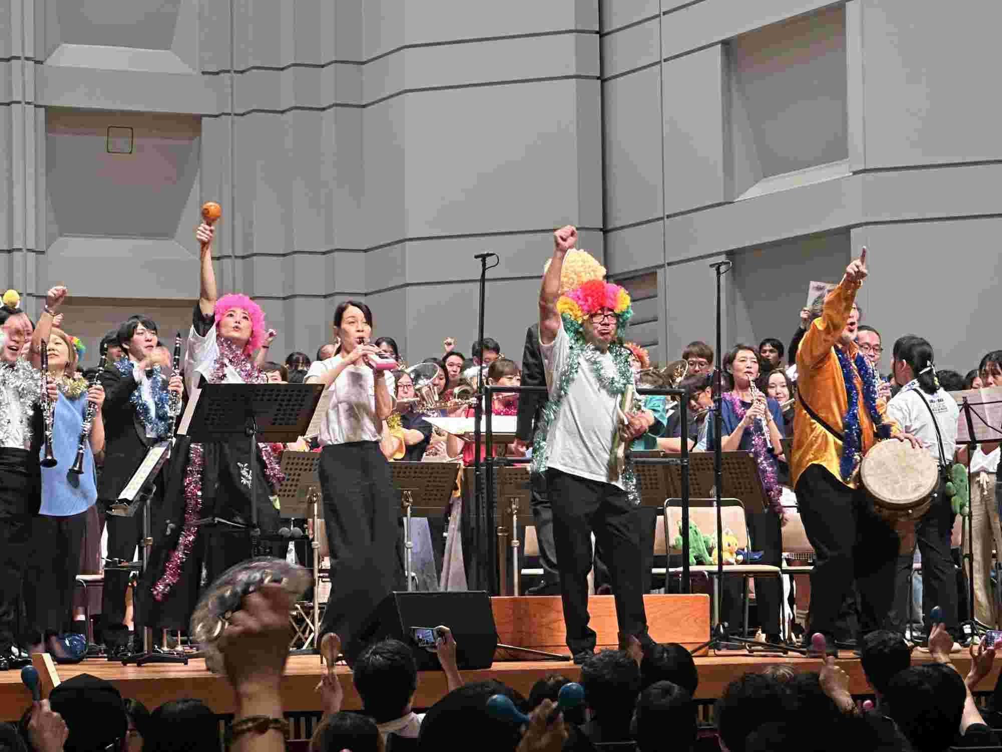 Musicians and audience members cheering and raising instruments during the BRA★BRA FINAL FANTASY 2024 concert finale