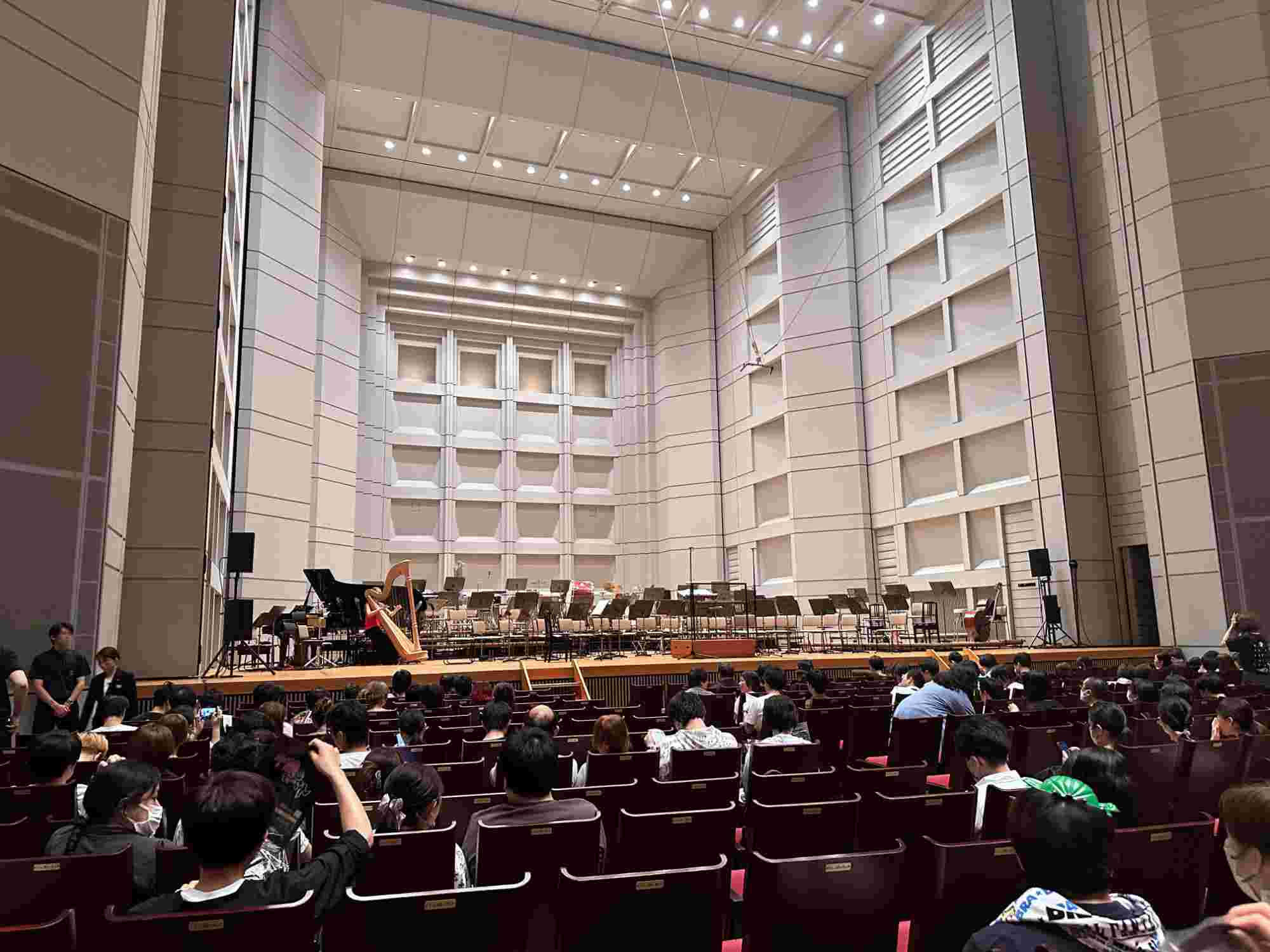 Audience seated and waiting for the BRA★BRA FINAL FANTASY 2024 concert to begin, with an empty stage set up for the orchestra